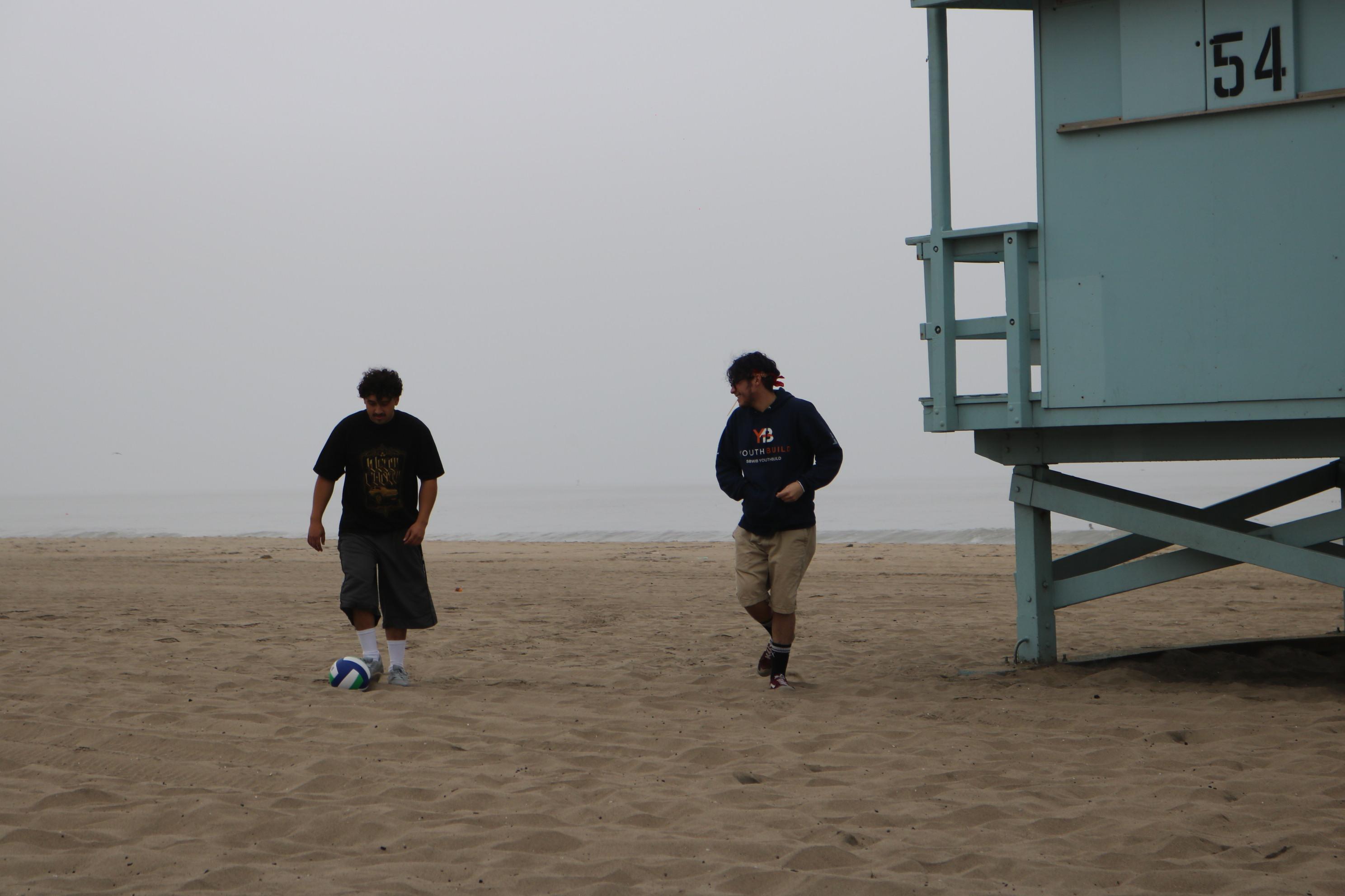 students play soccer on the beach