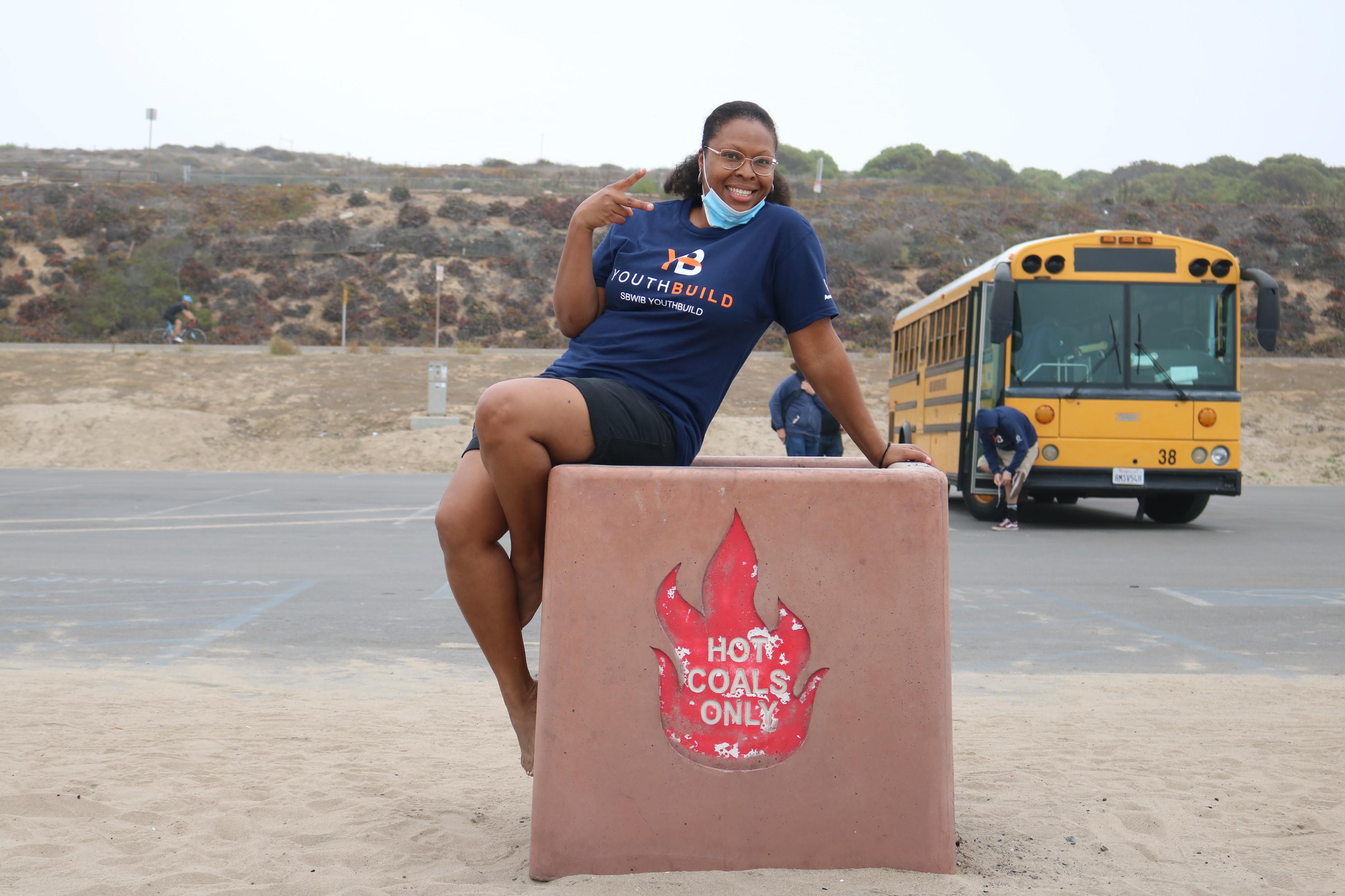 teacher Natasha Cabral flashes the peace sign outside the school bus at the beach