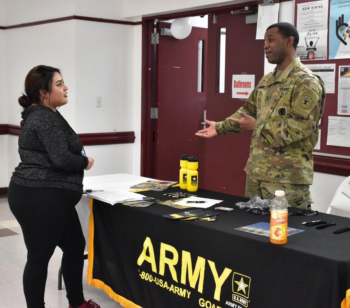 a YouthBuild student talks to a military recruiter at a Career Day event