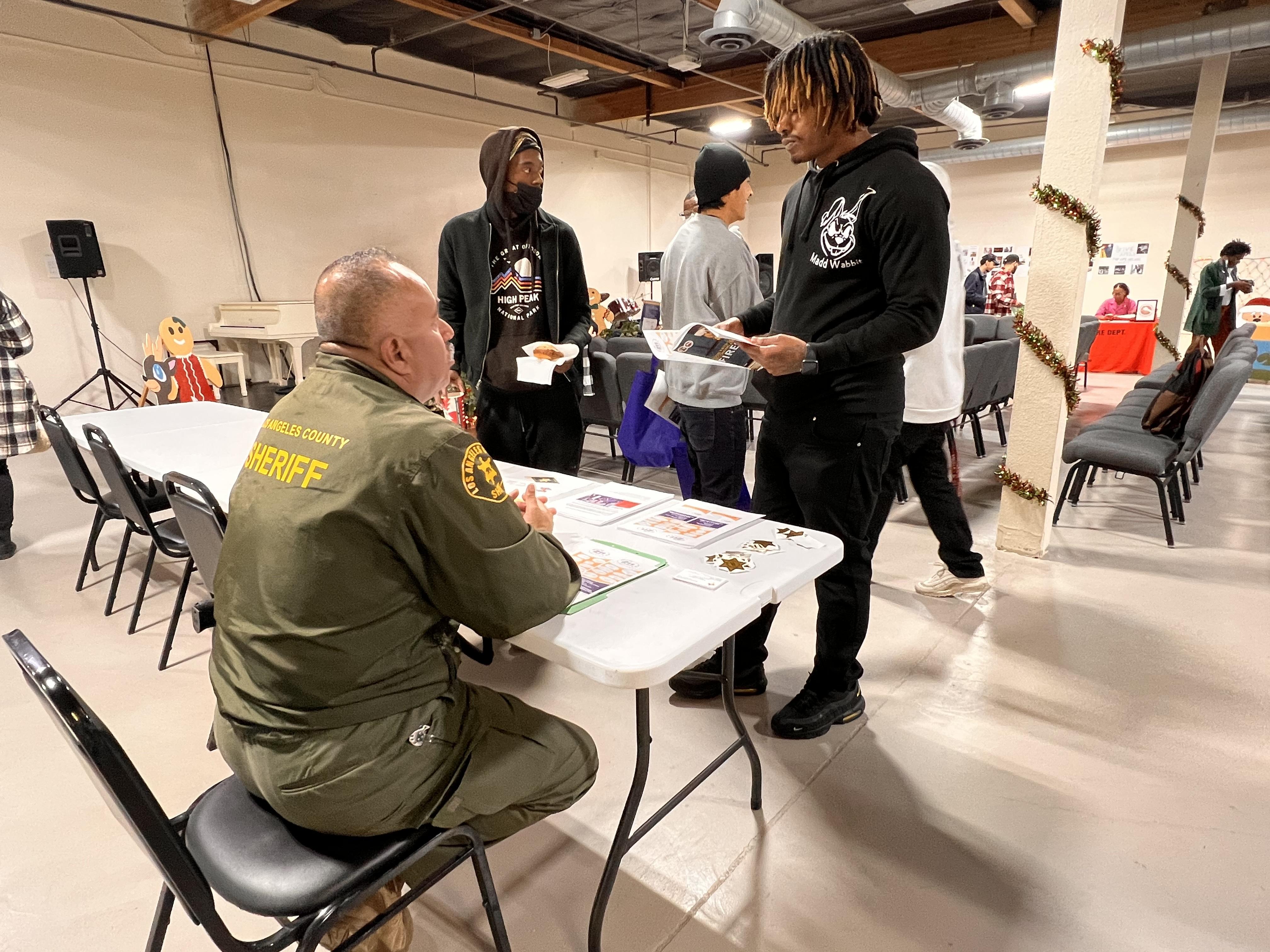 A student speaks to a sheriff at a table during the CAP