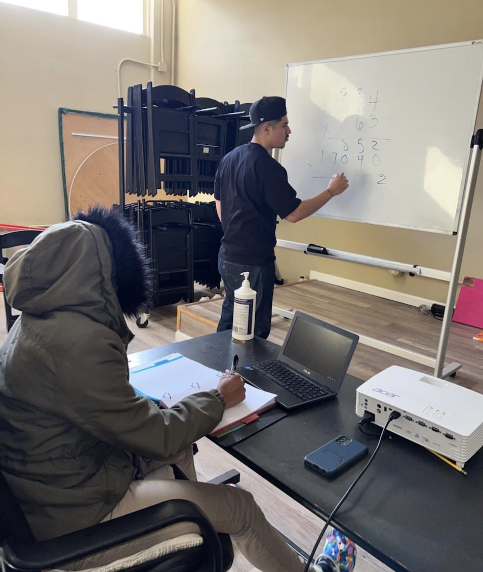 Jonathan teaching another student math on a whiteboard