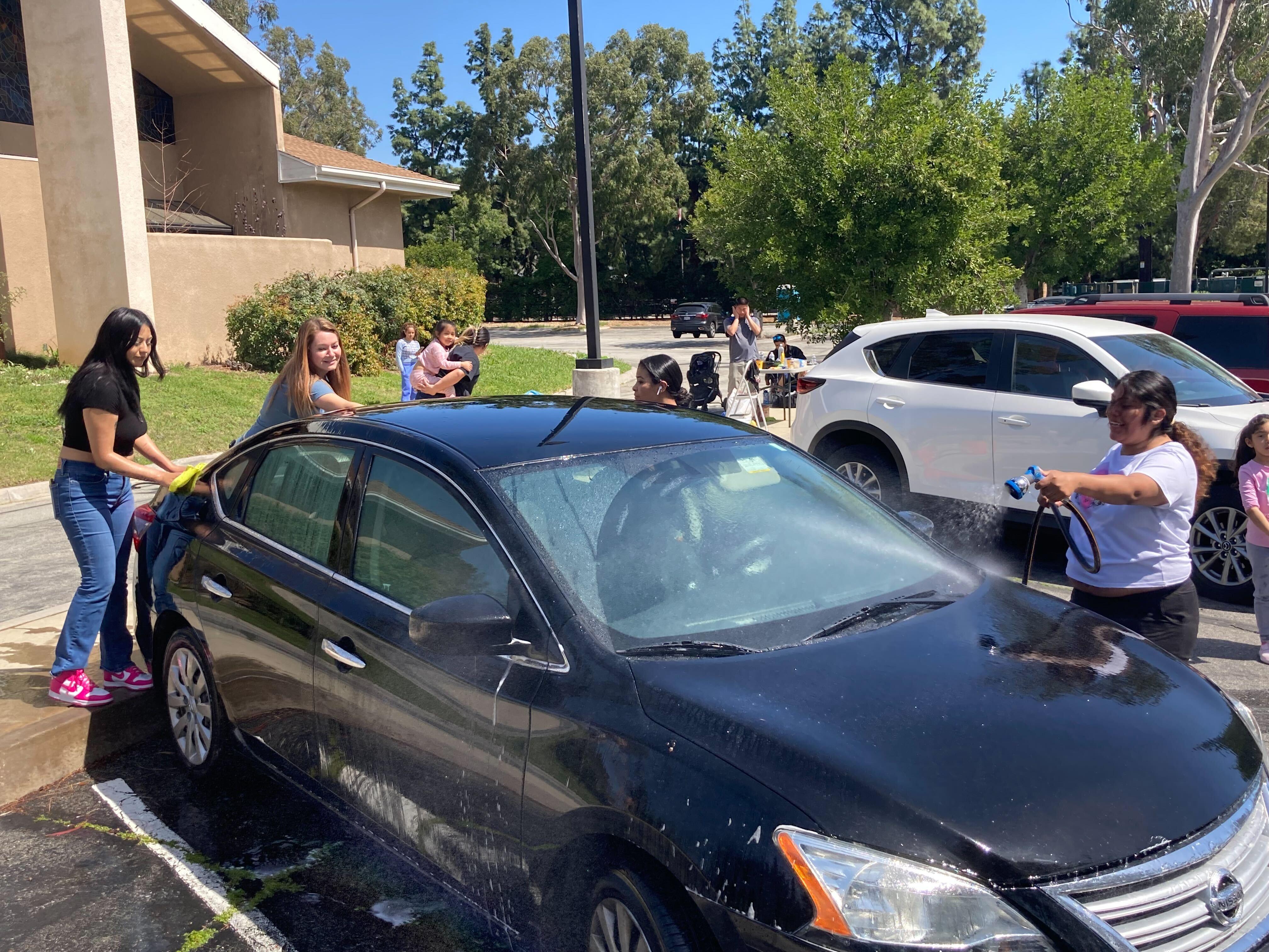 Students and Ms. M washing a car