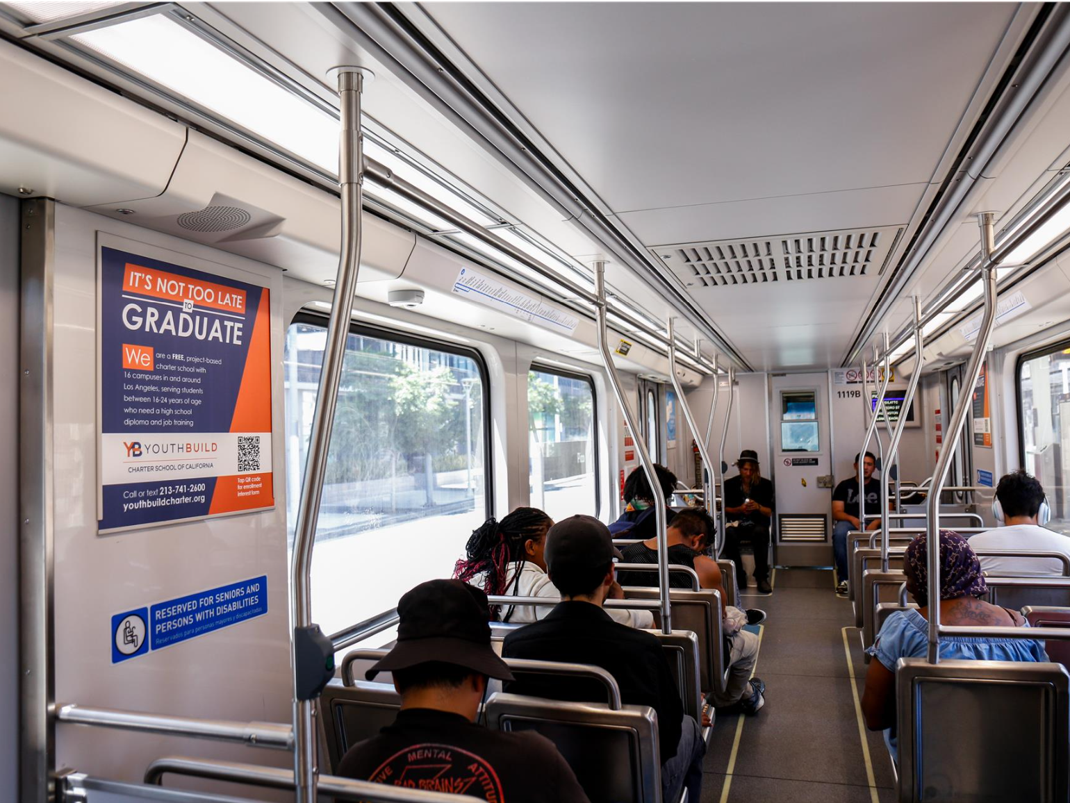 Metro rail riders on a train with our ad